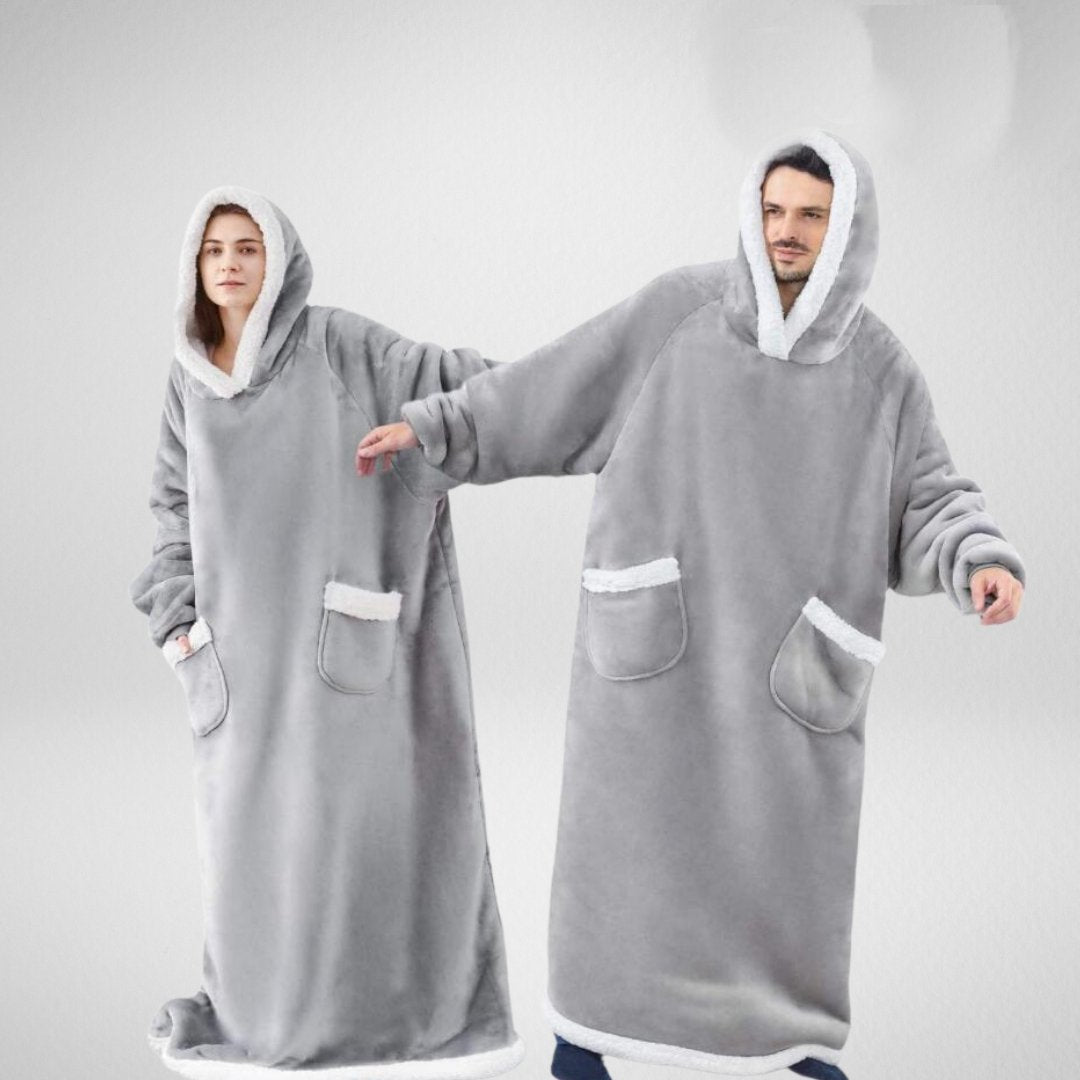 Oversized filt med huva, snyggt vikt på soffan, redo för mysiga hemmakvällar och heminredning.