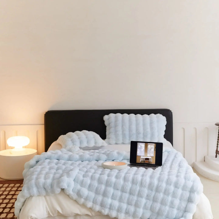 Elegant sängfilt i plysch, designad med ullstil. Tillför värme och en mysig atmosfär till ditt hem.