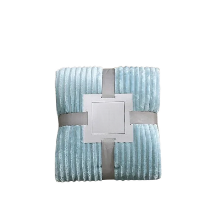 Heminredningsdetalj: randig flanellfilt elegant draperad över en soffa.