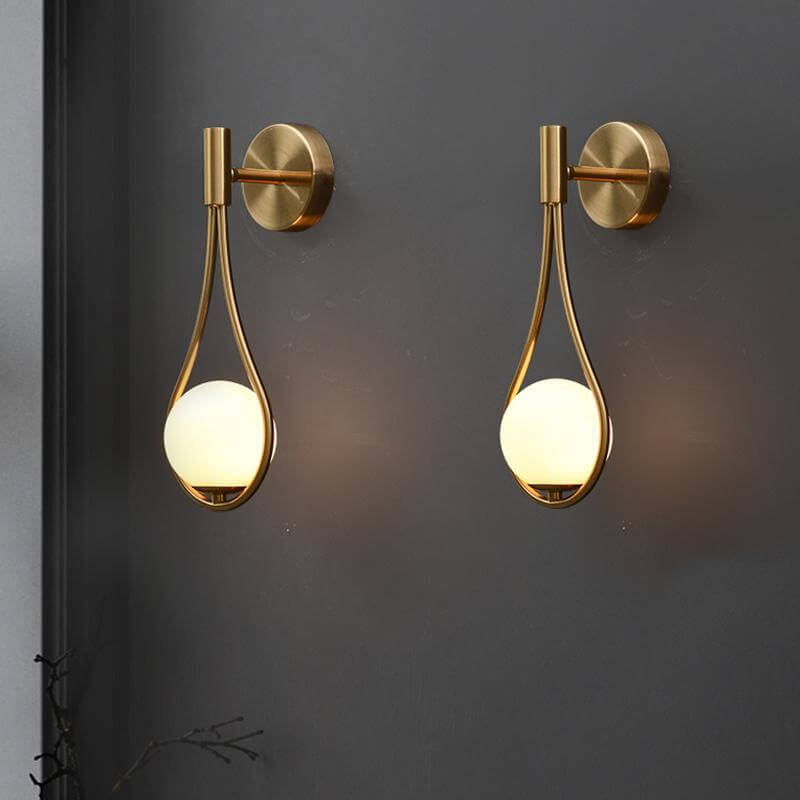 Stilren vägglampa i mässingsfärgad metall med nordisk design, perfekt för vardagsrummet.