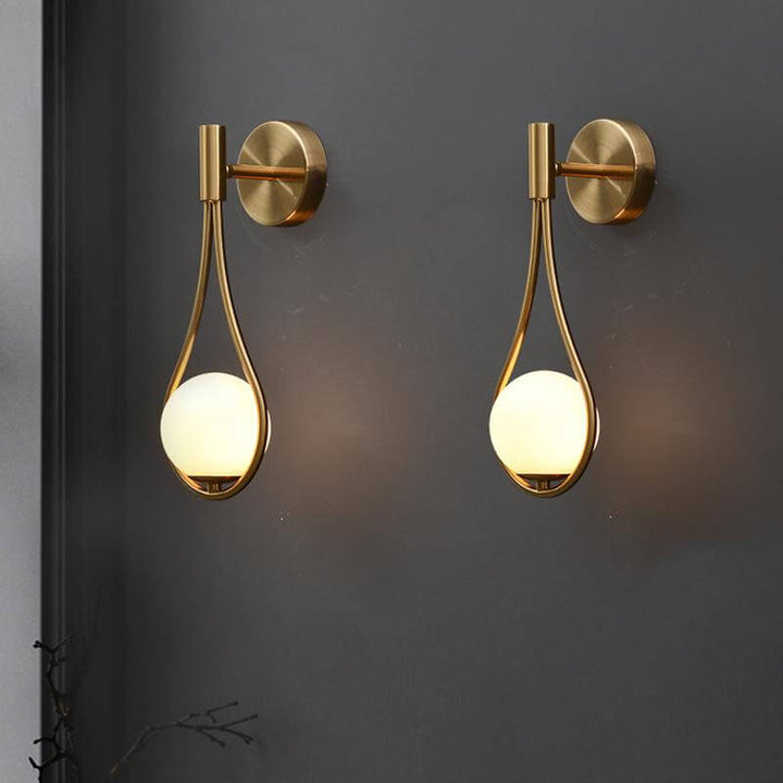Stilren vägglampa i mässingsfärgad metall med nordisk design, perfekt för vardagsrummet.