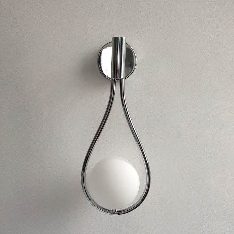 Modern vägglampa i metall monterad i vardagsrum, nordisk design som lyfter inredningen.