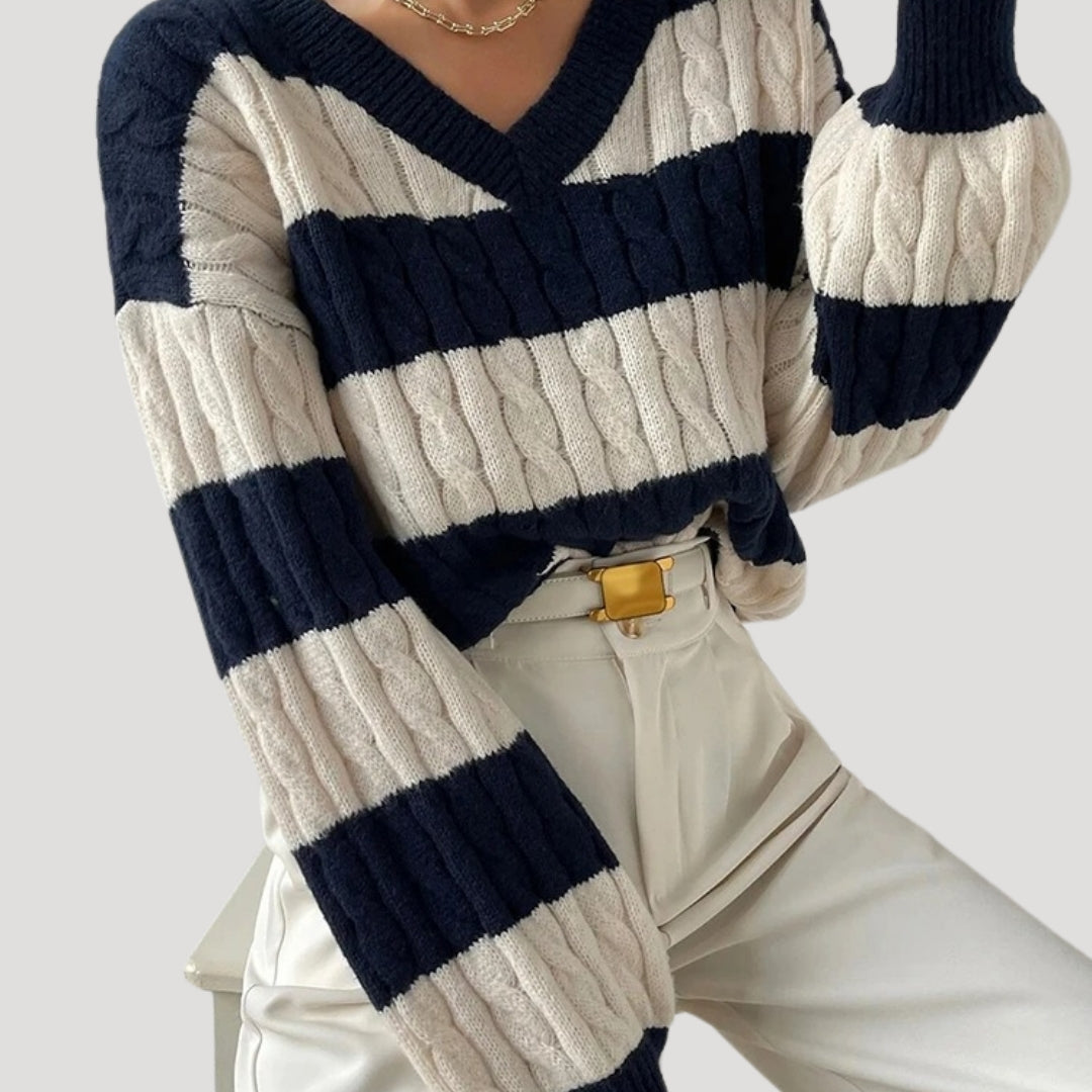 Modell bär bekväm oversized damtröja med v-ringning och randig design. Idealisk stickad tröja för damkläder.