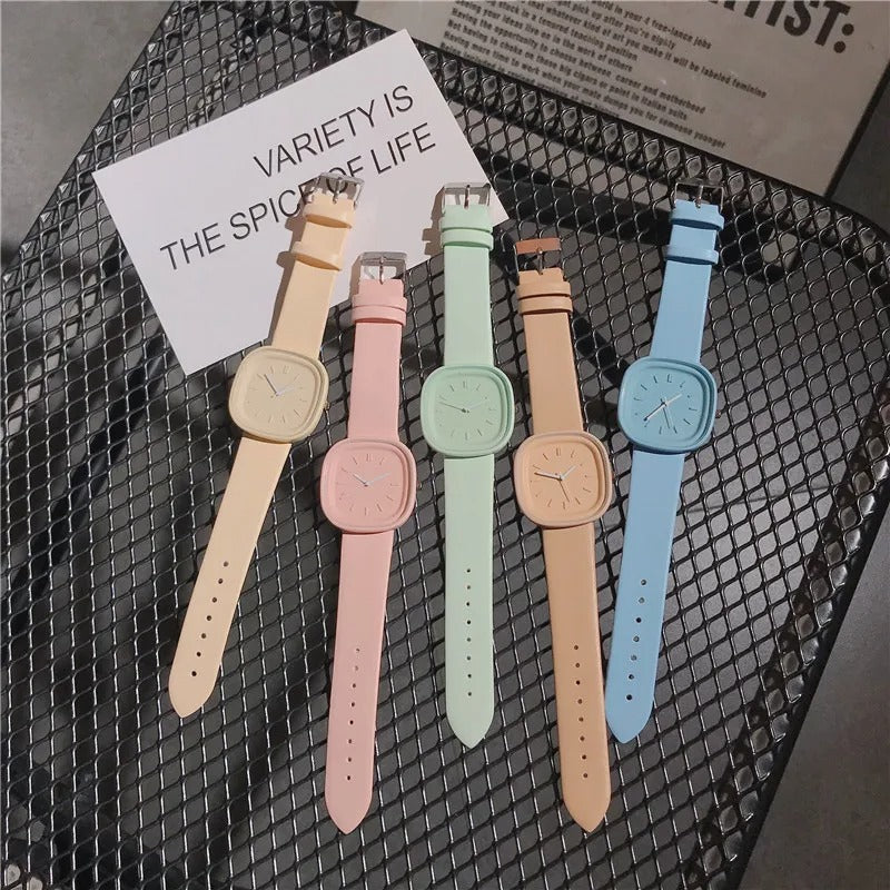 Kvinnors pastell armbandsur på handleden, trendig accessoar för en modern och sofistikerad look.