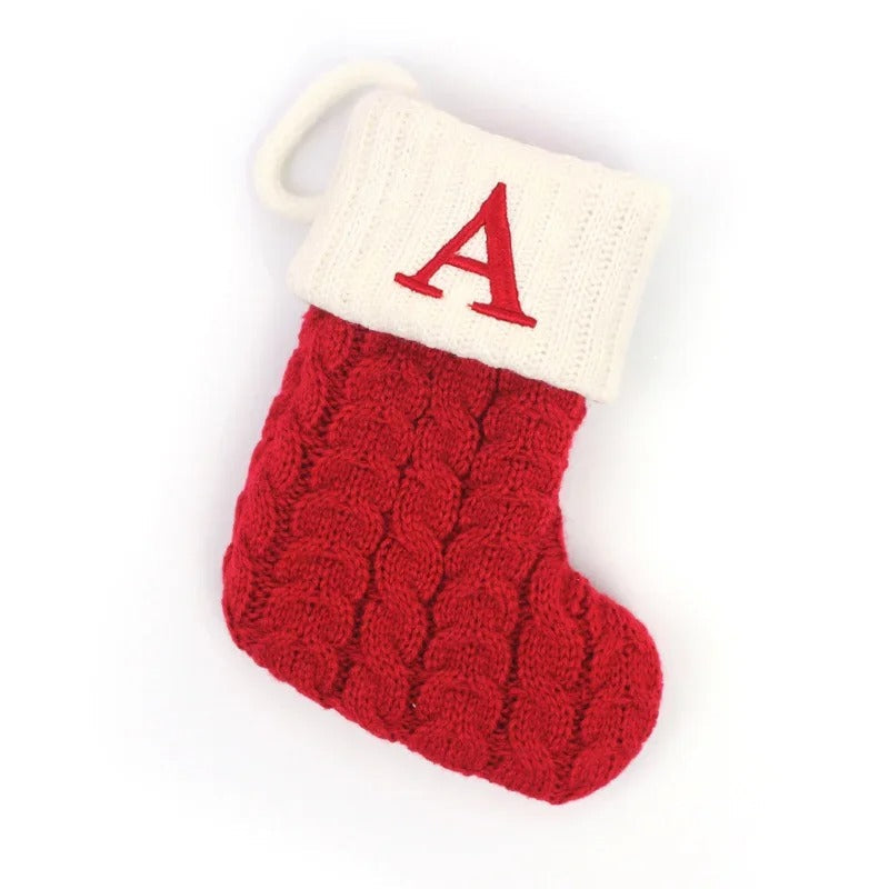 Personlig stickad julstrumpa med en liten gåva, en mysig juldekoration för festliga stunder.