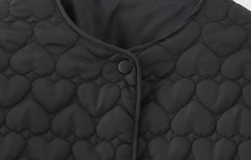Modell bär den stilrena quiltade damjackan med hjärtmönster. Perfekt ytterplagg för en chic höst- och vinterlook.