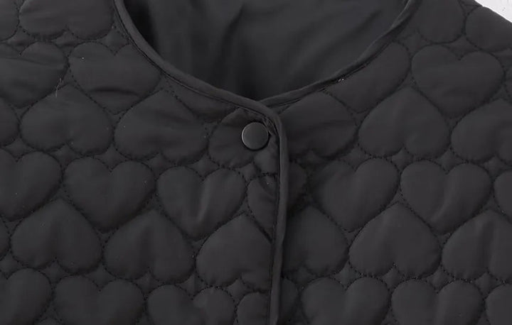 Modell bär den stilrena quiltade damjackan med hjärtmönster. Perfekt ytterplagg för en chic höst- och vinterlook.