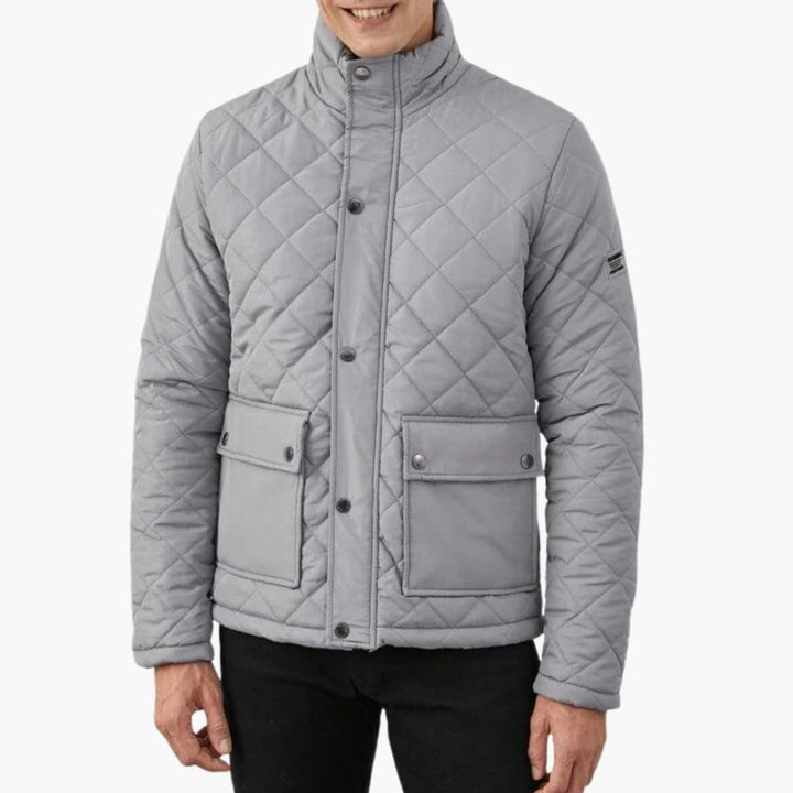 Närbild på den quiltade texturen hos en varm herrjacka, ett perfekt ytterplagg för kallare väder.