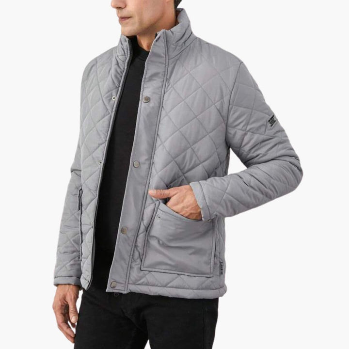 Quiltad herrjacka med stativkrage buren av man, visar stilren design för höst och vintermode.