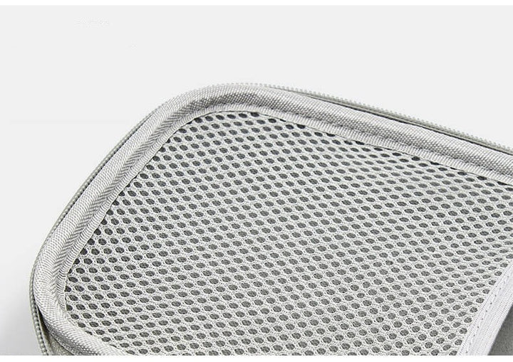 Tom kabelorganisatör som visar flexibla fack och elastiska band för maximal teknikförvaring.