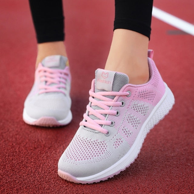 Närbild på ovandel av rosa mesh sneakers, visar detaljer i tyget