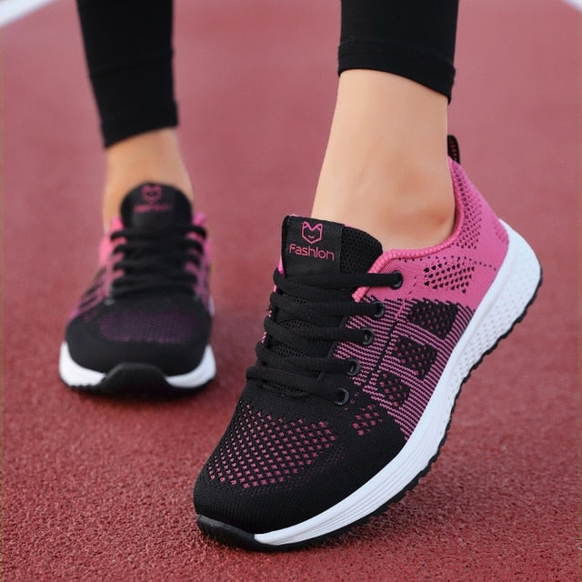 Kvinna som går i andningsbara rosa mesh sneakers, bekväma fritidsskor