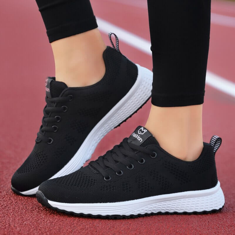 Vacker närbild av design på andningsbar mesh sneaker för dam, svarta