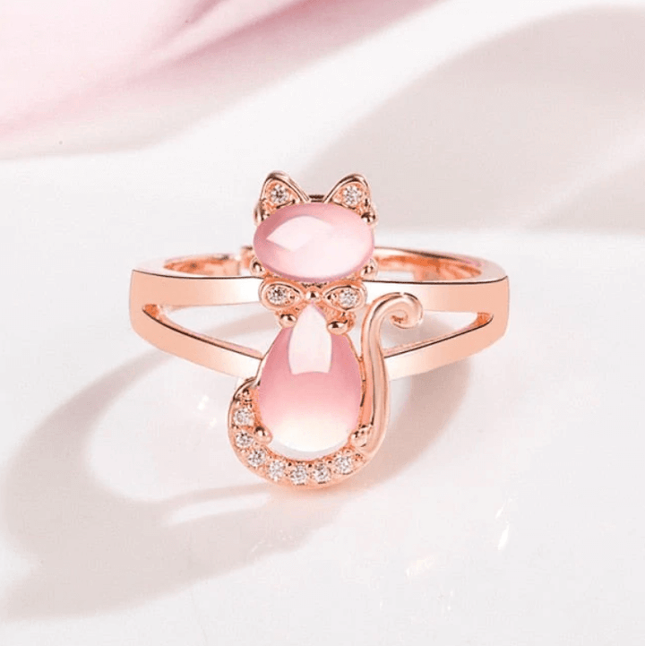 Elegant damring med rosa opal och kattmotiv, stilren accessoar.