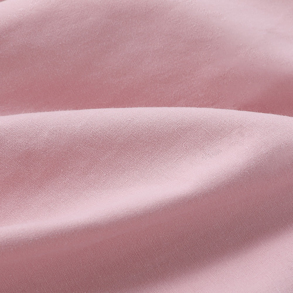 Närbild på det högkvalitativa tyget och spetsdetaljerna på den rosa dirndl klänningen.
