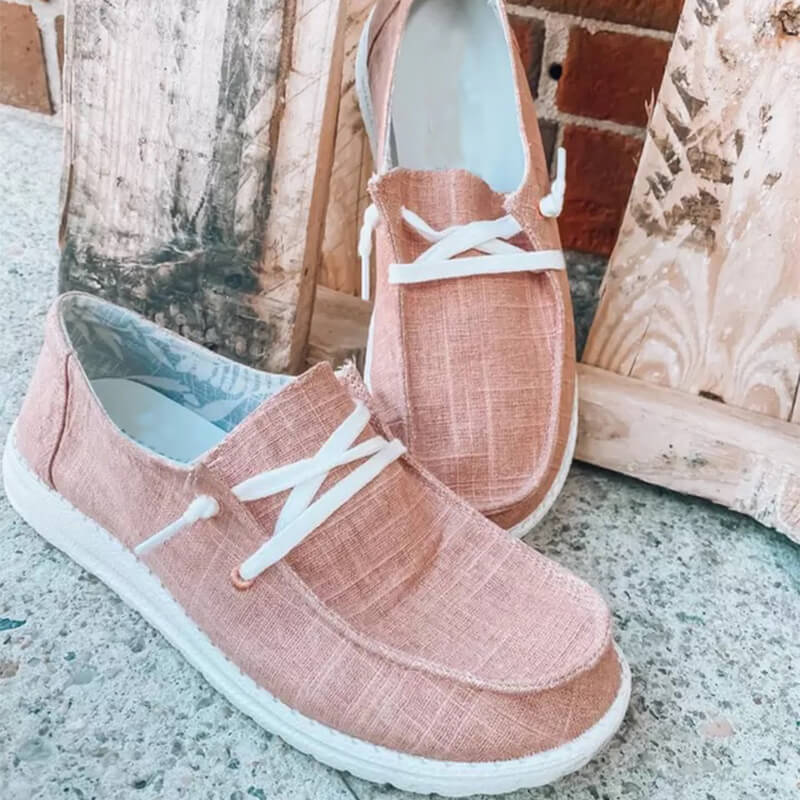 Ovanifrån vy av bekväma rosa rutiga canvas loafers med dekorativ snörning