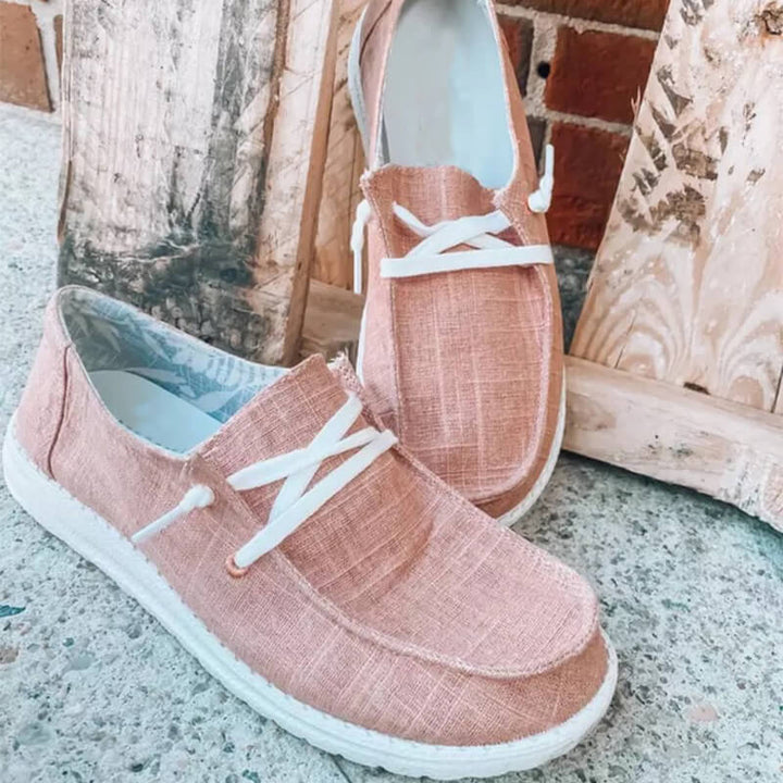 Ovanifrån vy av bekväma rosa rutiga canvas loafers med dekorativ snörning