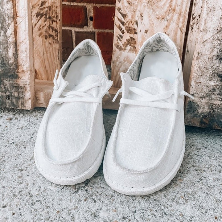 Sista exemplaret av rosa rutiga canvas loafers damskor med snörning på vit bakgrund