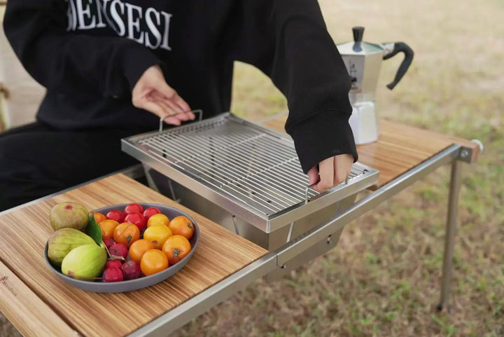 Slitstark, kompakt bärbar grill i rostfritt stål för camping, picknick och utomhusmatlagning.