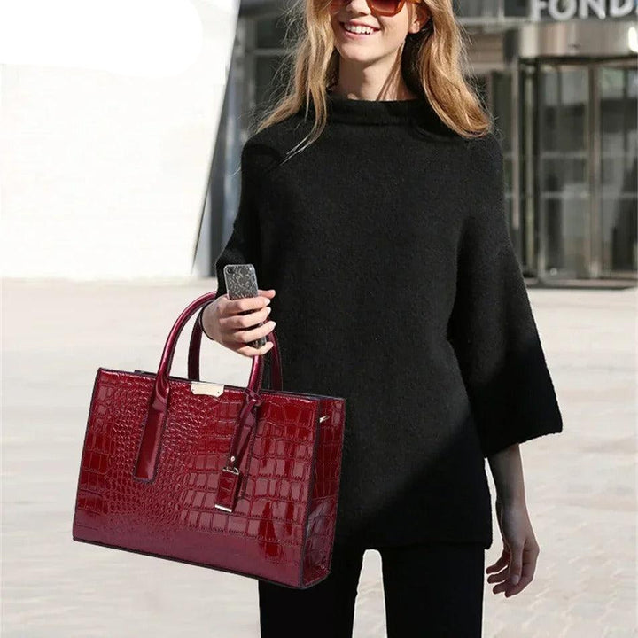 Unik damväska med texturerat krokodiltryck, en stilren och rymlig totebag. Elegant accessoar.