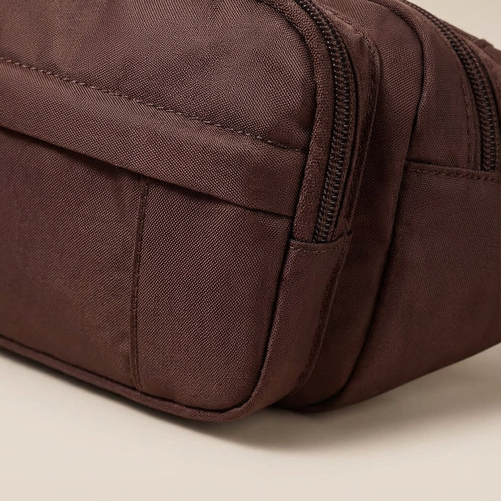 Vattentålig rese-fannypack med rymliga fack för säker organisering av värdesaker.