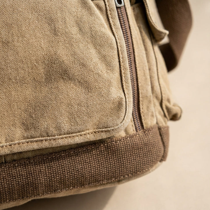 Unisex vintage axelväska i khaki canvas bärs över axeln. Perfekt robust vardagsväska för dokument & laptop.