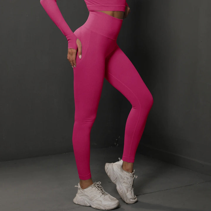 Kvinna lyfter vikter i högmidjade gymleggings, sömlösa och bekväma för intensiv fitness.