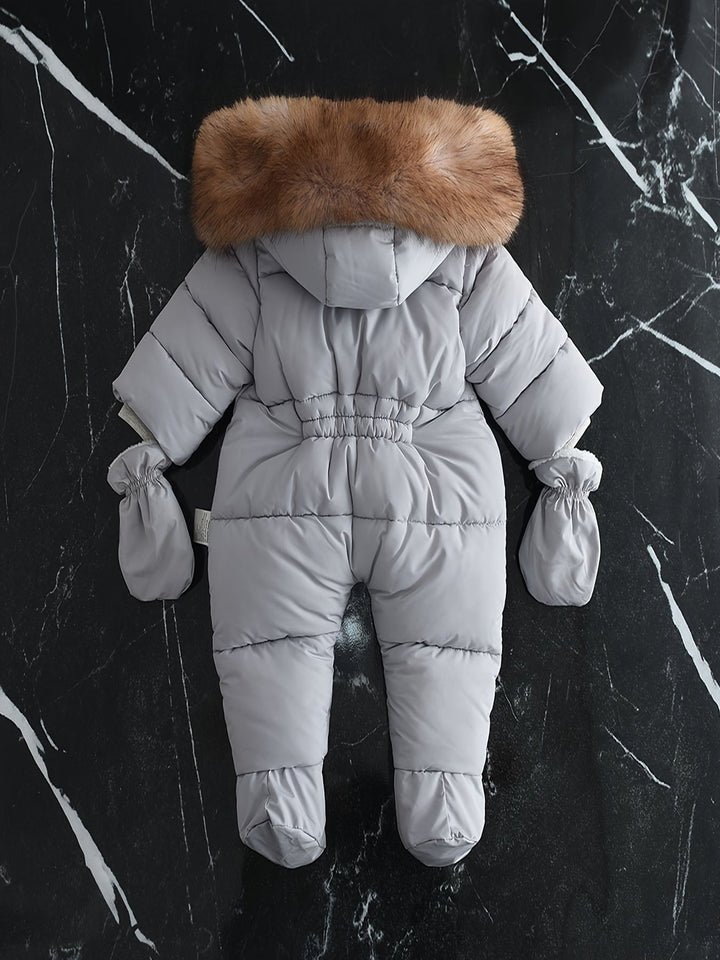 Praktisk vinteroverall för baby med integrerade handvärmare och huva för maximal värme.