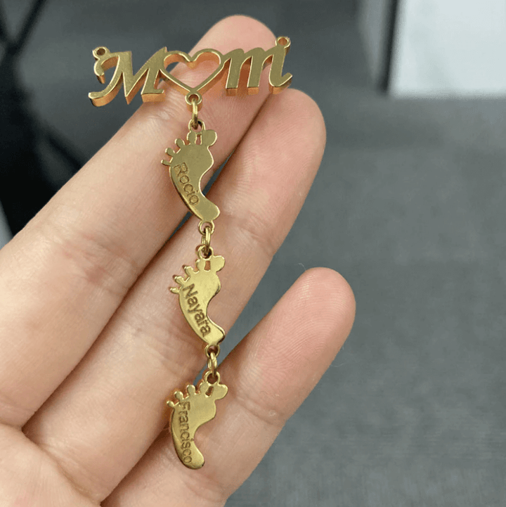 Familjesmycke: Mammahalsband i silver med symboliska babyfötter. Beställ din personliga gravyr idag.