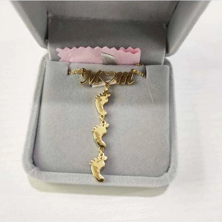 Mammahalsband i silver med personlig gravyr av namn och babyfötter. Vacker present till mamma.