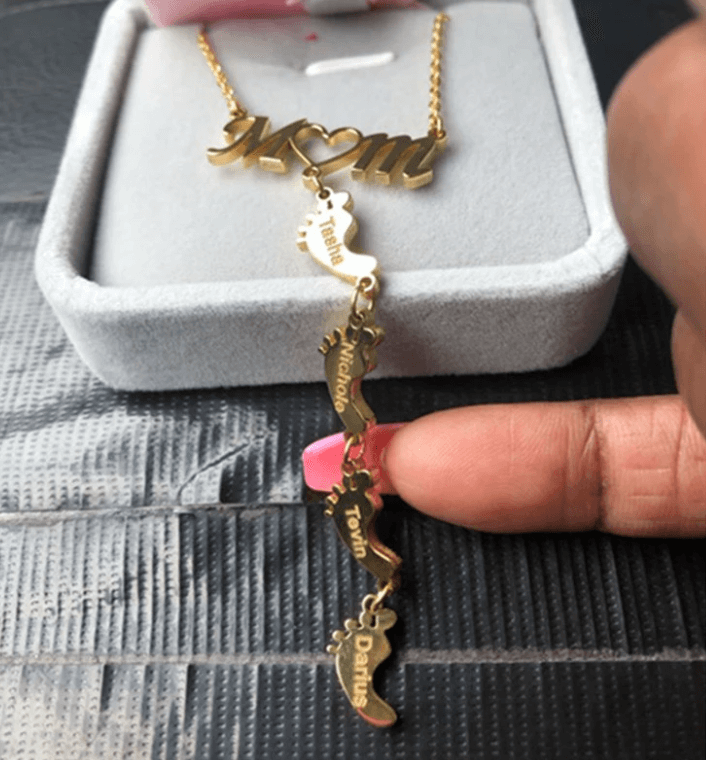 Guldpläterat mammahalsband med babyfötter i modern design. Ett personligt smycke för mors dag.