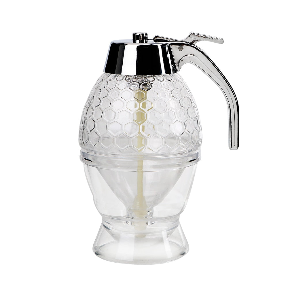 Droppfri sirapsdispenser i glas och plast, ett praktiskt serveringsredskap för frukostbordet.
