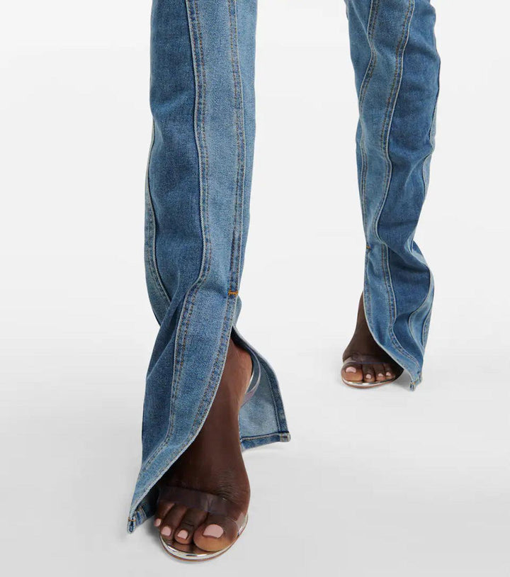 Helfigur av modell som bär snygga damjeans med hög midja och färgblockering i blått och svart.