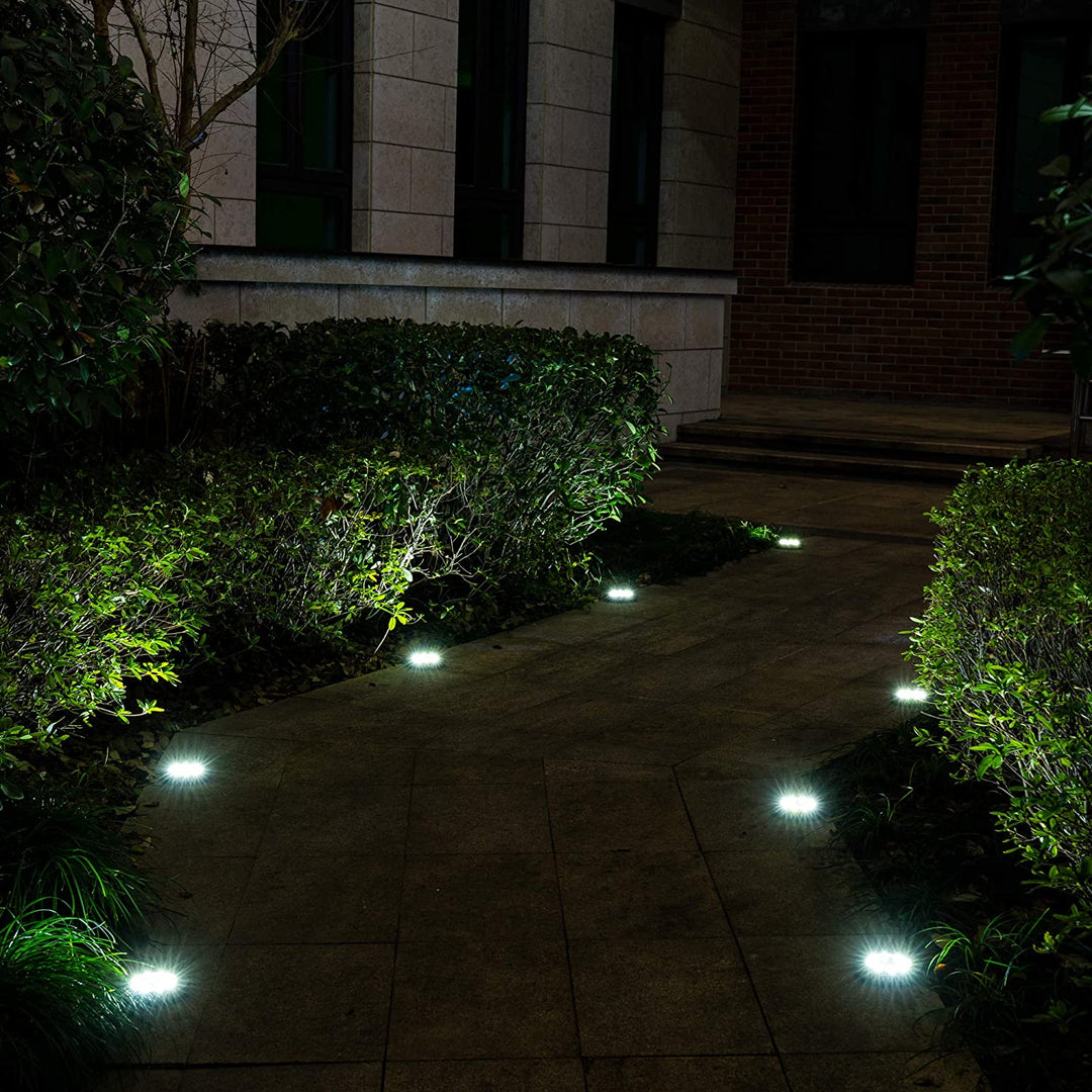 Klar vit LED utomhusbelysning från markspotlights ramar in en uteplats. Energisnål och enkel installation.
