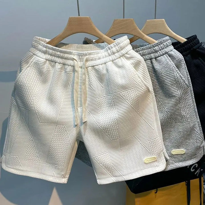 Man i aktiva sportshorts med vågmönster tränar. Bekväma herrshorts för löpning och gym.