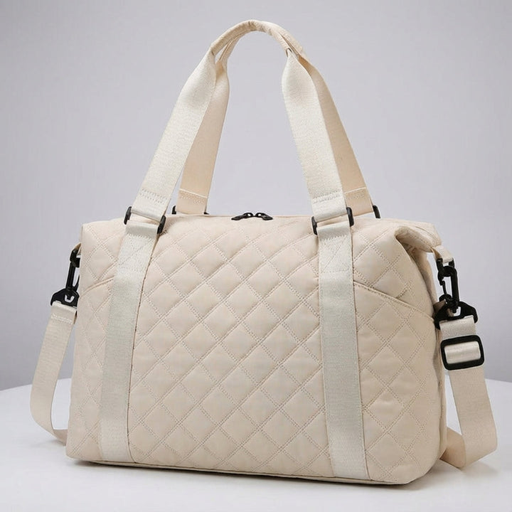 Quiltad weekendväska, idealisk som gymväska eller handbagage. Mjuk vadderad design för bekväma resor.