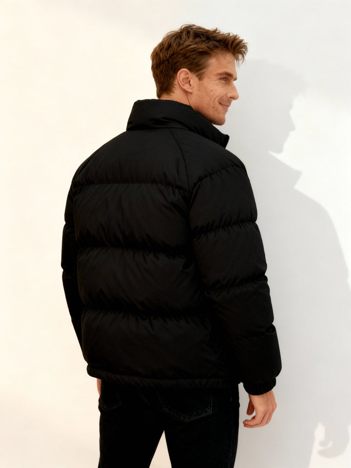 Varm svart pufferjacka för herr. Idealisk som vinterjacka & stilrent ytterplagg för streetwear.