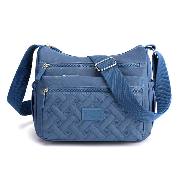 Modern modeaccessoar: crossbody damväska med justerbar rem och smarta fack. Funktionell och stilren.