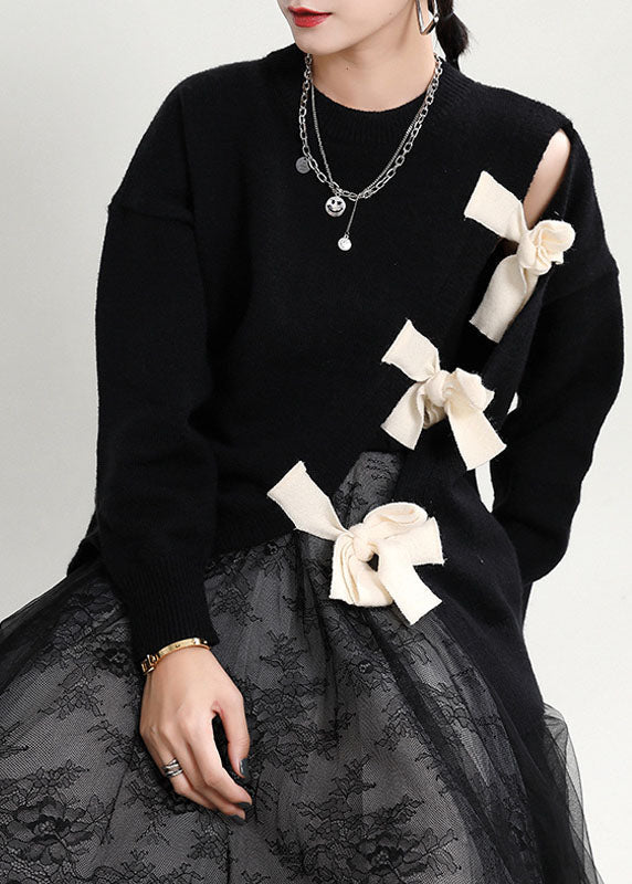 Mysig svart patchwork damtröja med asymmetrisk design. Lös passform, perfekt för bekväm höststil.