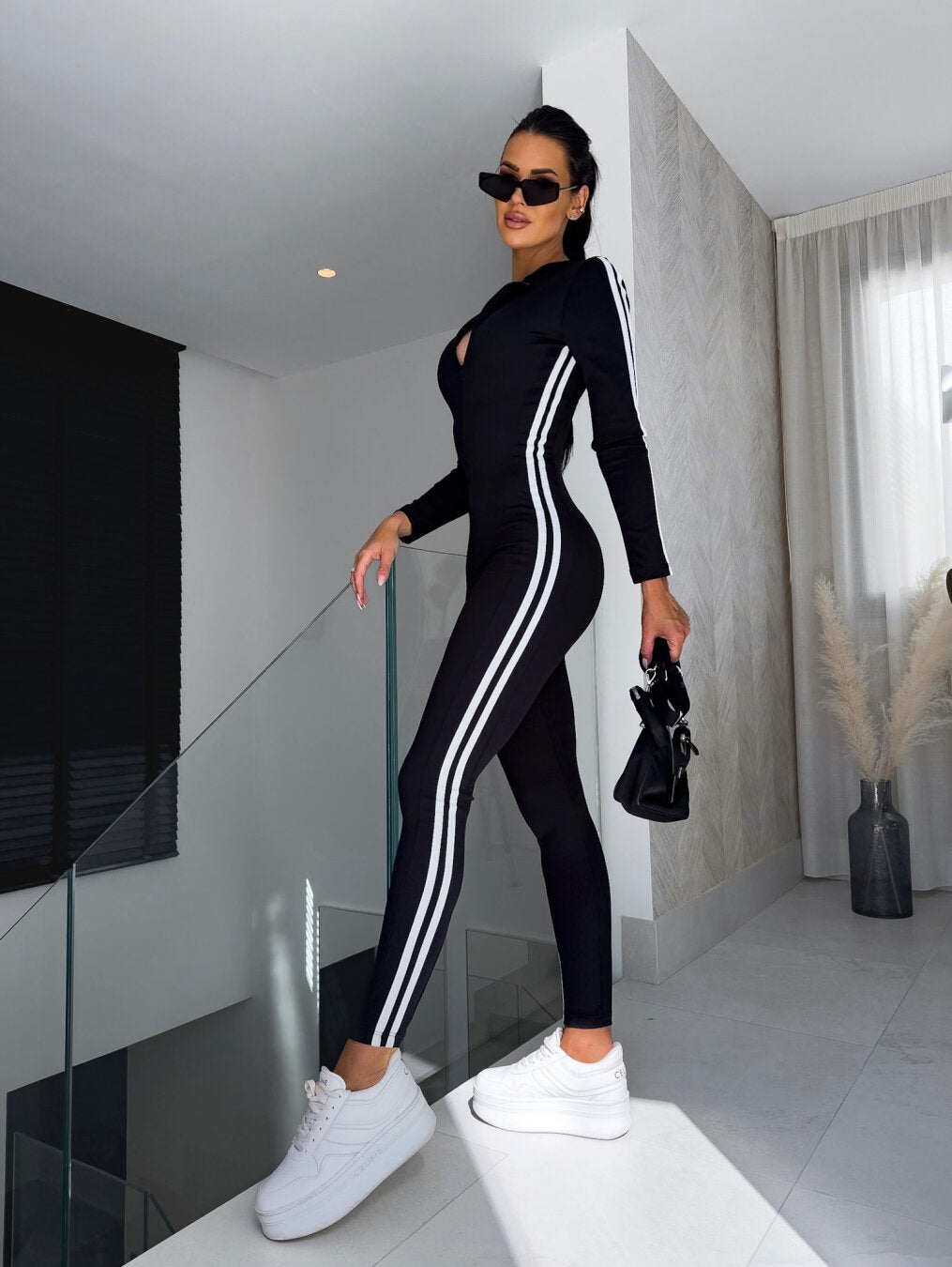 Bekväm dam byxdress med vågiga ränder, perfekt för vardag och fest. Svart sportig jumpsuit i elegant stil.