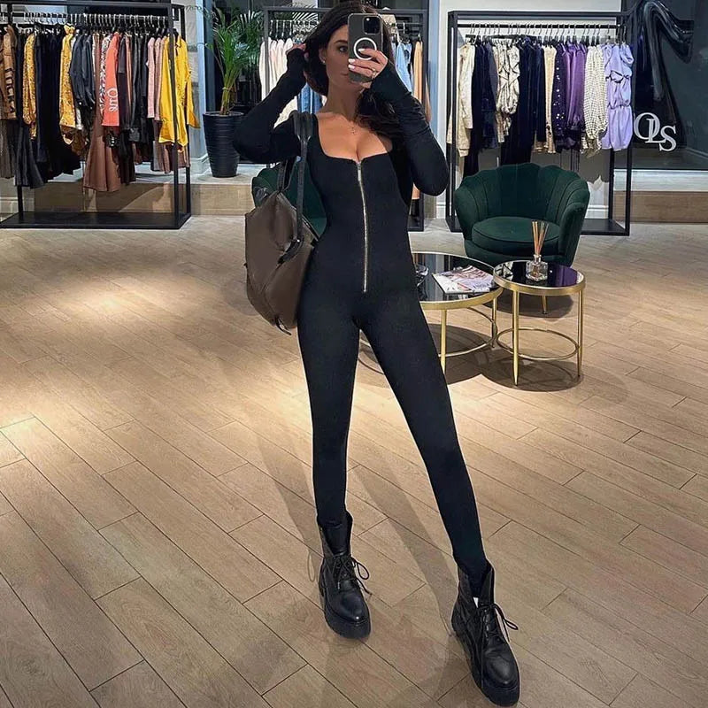 Damjumpsuit i svart med distinkt fyrkantig halsringning, figurnära passform. För en elegant kvällsoutfit.