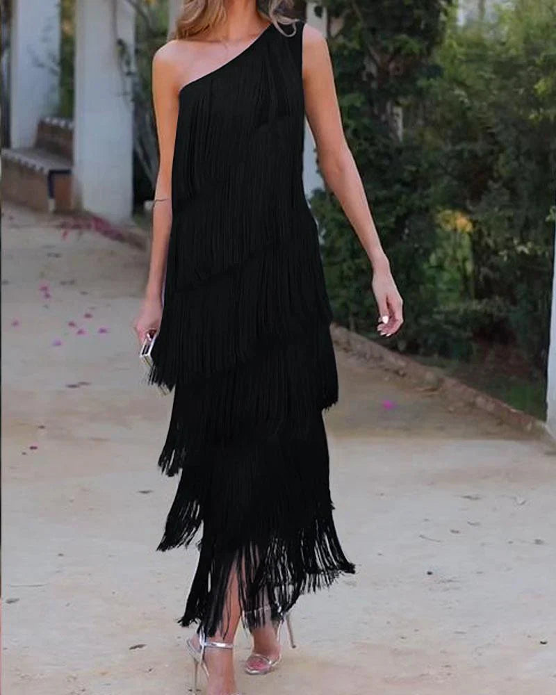Trendig kvinnors festklänning i svart med off-shoulder design och lekfulla fransar. En chic cocktailklänning.