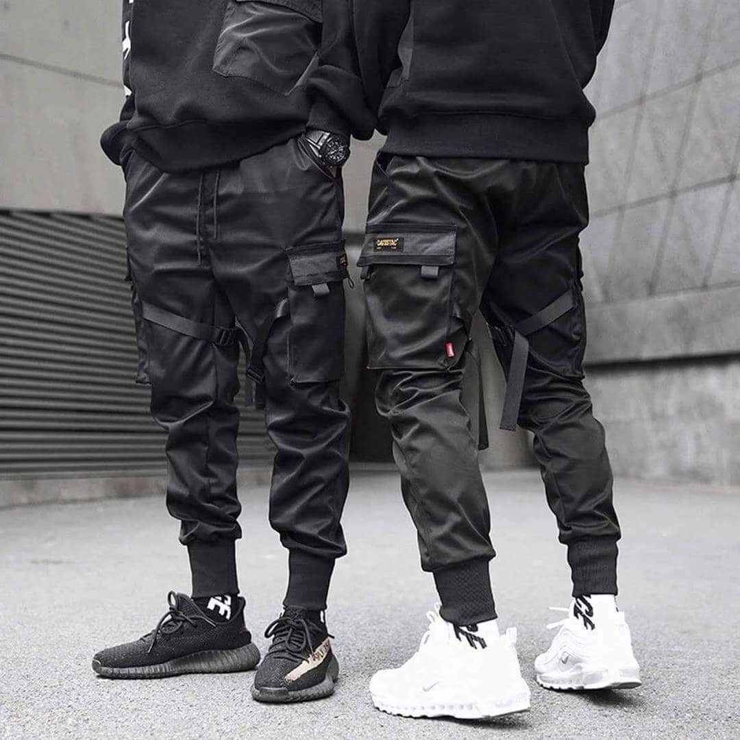 Man bär svarta cargobyxor med löspassform i modern streetwear-stil, bekväma för fritid och stadsliv.