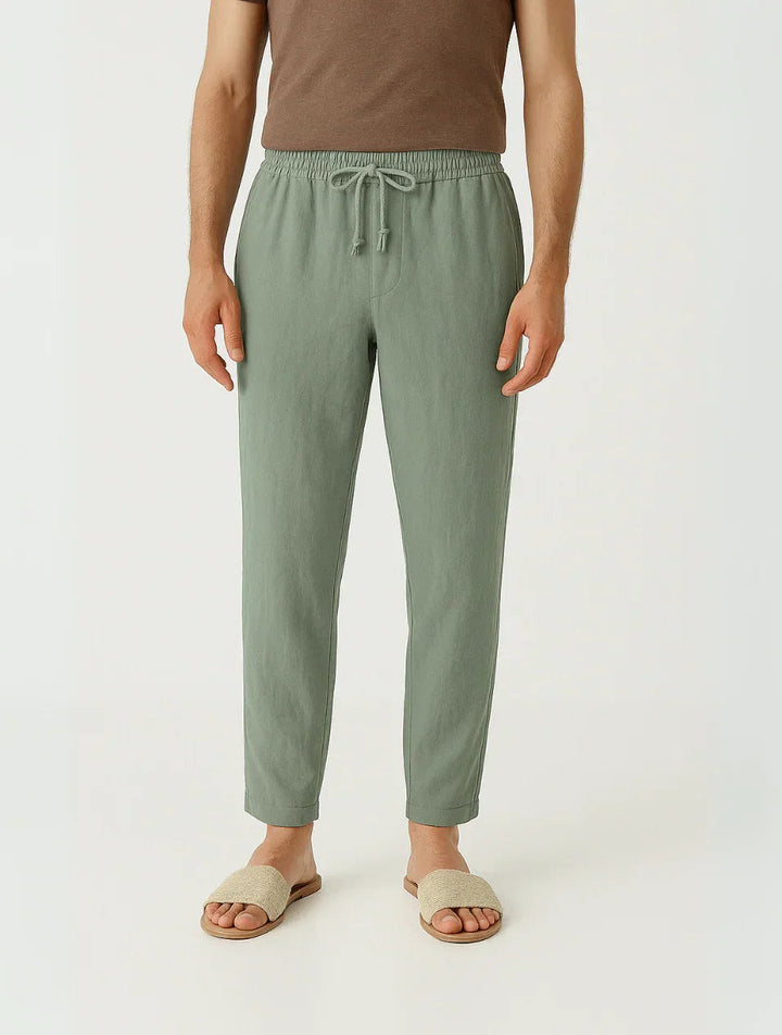 Man i blå avslappnade herrbyxor med avsmalnande passform, visar bekväm sommarstil och fritidslook.