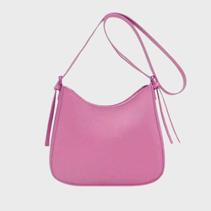 Kvinnors minimalistiska crossbody väska buren på axeln, perfekt för en stilren och kompakt look.