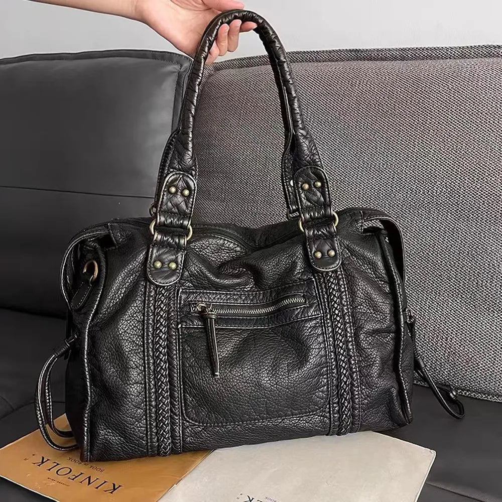Vintage-inspirerad svart damväska i syntetläder. Mångsidig skolväska, crossbody eller arbetsväska med stil.