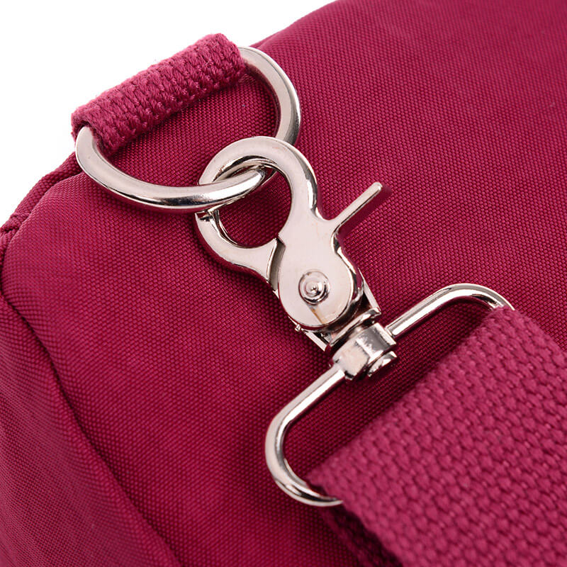 Svart Casual Crossbody väska placerad på ett bord, bredvid en mobiltelefon och plånbok, vardagsväska.