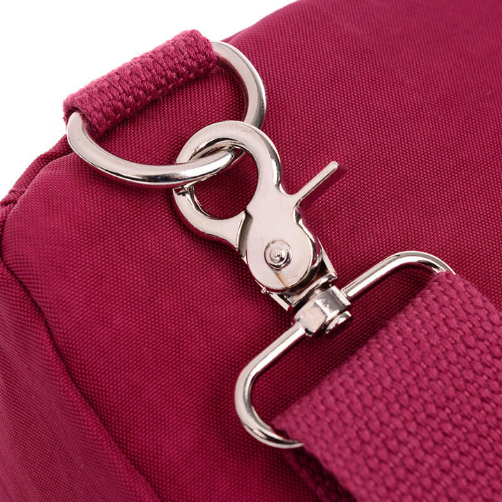 Svart Casual Crossbody väska placerad på ett bord, bredvid en mobiltelefon och plånbok, vardagsväska.