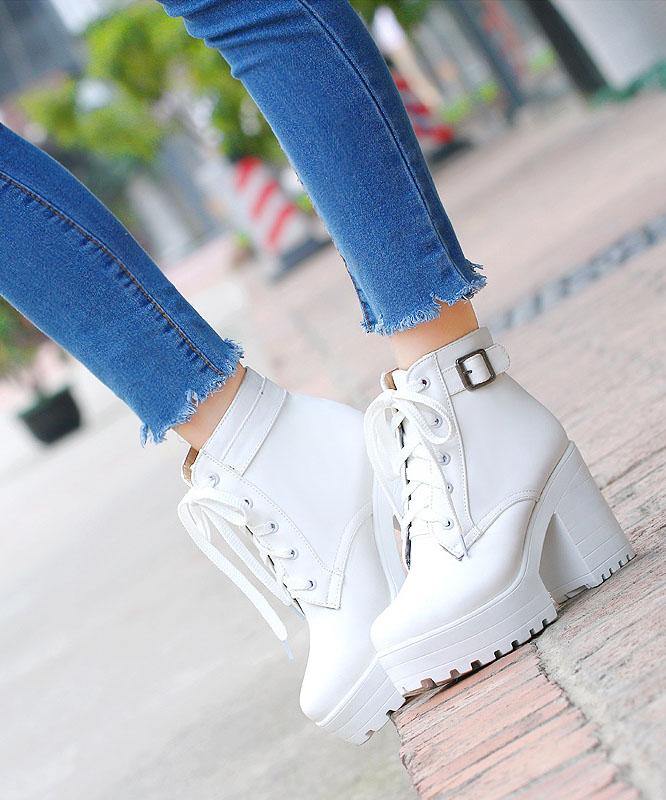 Detaljvy av trendiga svarta chunky boots. Korsremmar, kraftig gummisula och hög klack för stilfullt vintermode.