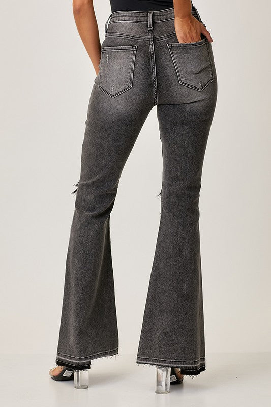 Detaljbild av faded svarta damjeans med hög midja och snyggt utsvängda byxben